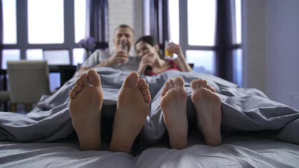  Bare Feet of Young Couple Under Blanket