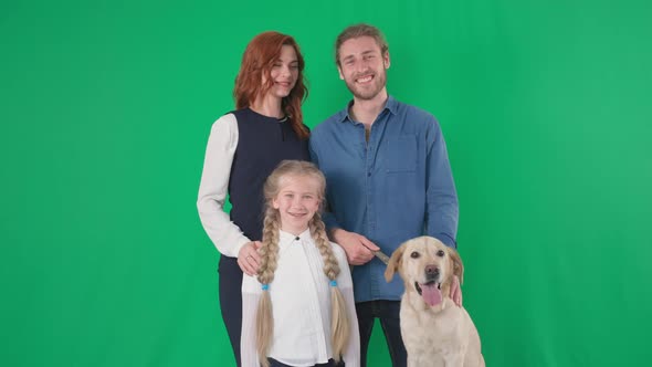 Portrait of Happy Family of Loving Male and Female Parents with an Adorable Girl and Labrador Dog