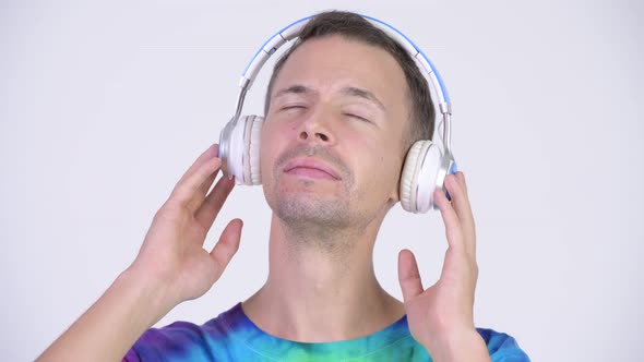 Studio Shot of Happy Man Wearing Tie-dye Shirt and Listening To Music