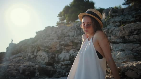 Woman is Sitting on Basalt Rocks in Summer Day