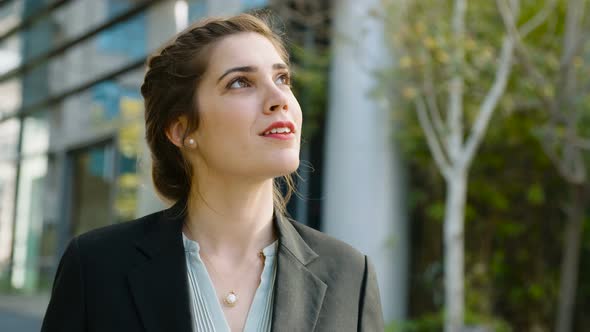 Young business woman walking on the street talking on her mobile phone