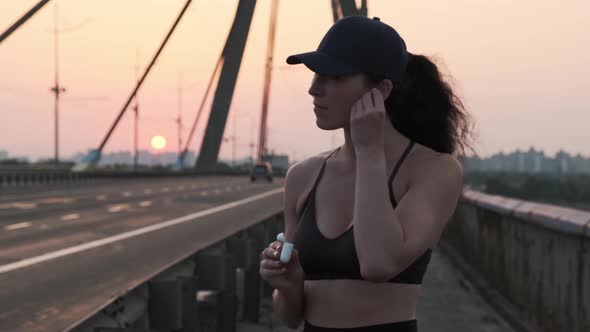 Young Sporty Woman Using Her Earphones Before Run