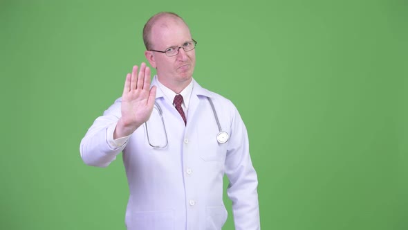 Mature Bald Man Doctor with Stop Hand Gesture