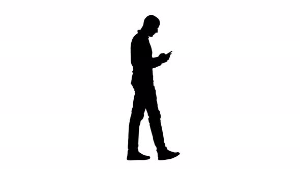 Silhouette Young Man Walking and Using a Phone