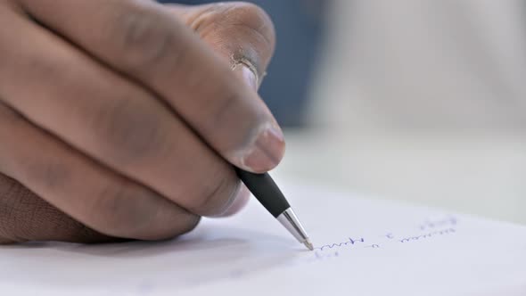 Close Up Young African Man Hand Writing on Paper 