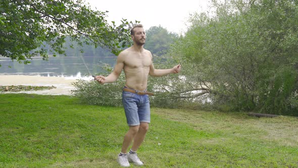 Sportsman man jumping rope in the forest.