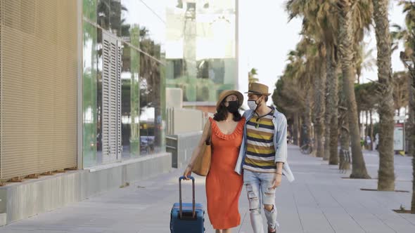 Young Couple of Travelers Having Fun Outside Wearing Safety Masks During Coronavirus Outbreak
