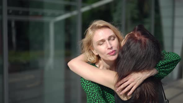 Portrait of Happy Excited Woman Hugging Friend Meeting Lady in City on Sunny Day