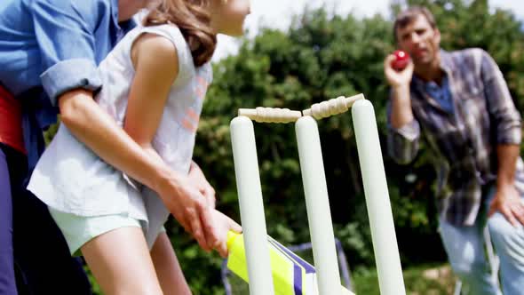 Happy family playing cricket