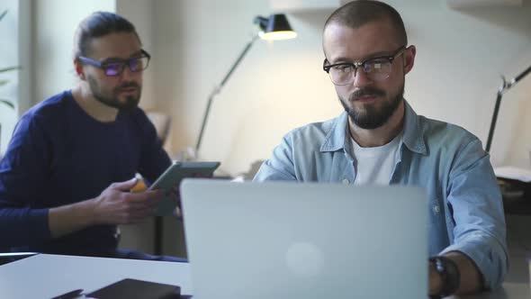 Confident Male Caucasian Business and Consultant Adviser Talking. Workplace with Laptop and Tablet