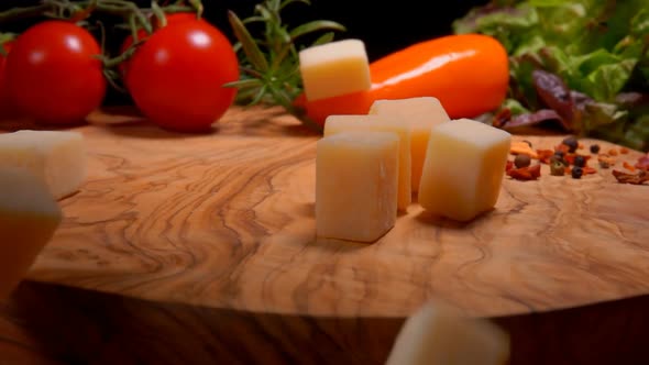 Hard Cheese Cubes Fall on a Board with Spices