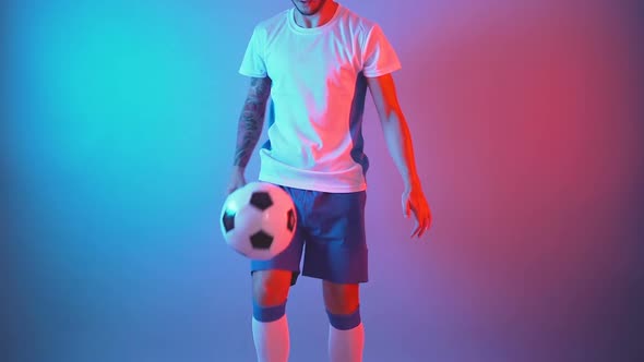 Slow Motion of Male Professional Soccer Player Juggling Ball on Leg Indoor Studio 