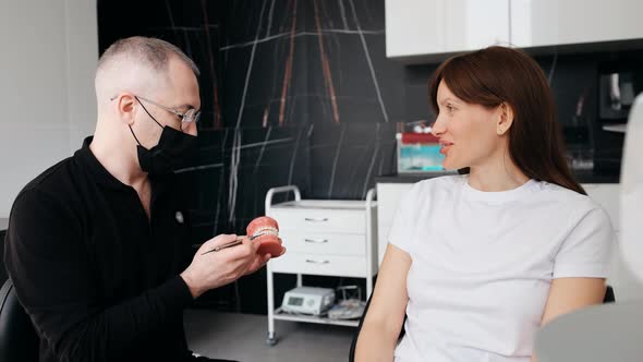 Dentist and Patient Discuss Treatment Plan Using Dental Models