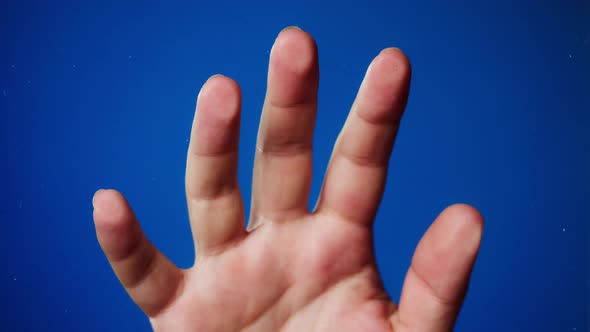Human Hand Making Fingerprints on Blue Background
