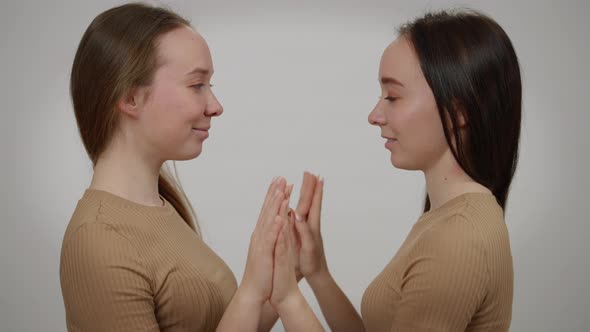 Two Happy Smiling Beautiful Slim Women Touching Hands Palms Looking at Each Other