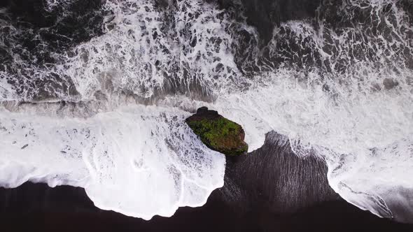 Drone Flight Towards Sea Stack In Surging Surf On Black Sand Beach