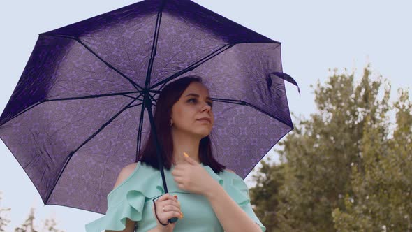 Thoughtful Woman with Umbrella in Cloudy and Windy Weather