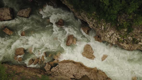 Aerial Drone Top View of a Deep Hadzhokh Gorge and Fast White Stream of River Belaya 