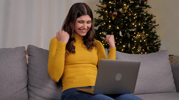 Excited Woman Winner Looks at Laptop Celebrating Good Online New Year Purchase