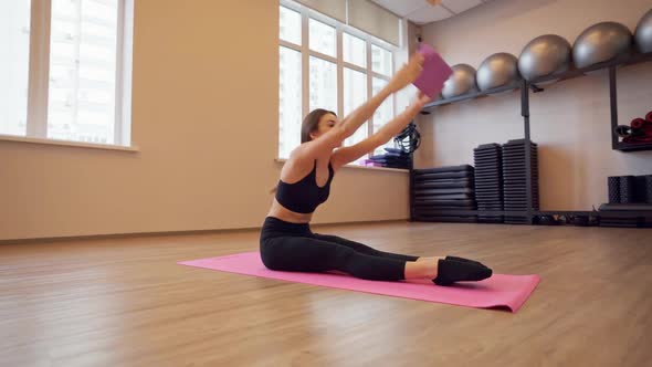 Beautiful Young Woman Working Out and Stretching Indoors