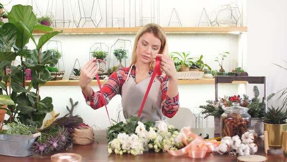Young Female Florist with Red Ribbon for Flowers
