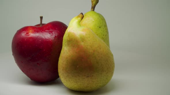 Fresh Red Apple and Two Beautiful Fresh Pears Rotating Clockwise With Pure White Background - Close