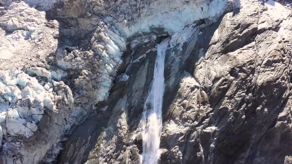 Aerial view of a waterfall with melt water from a dying glacier in Switzerland