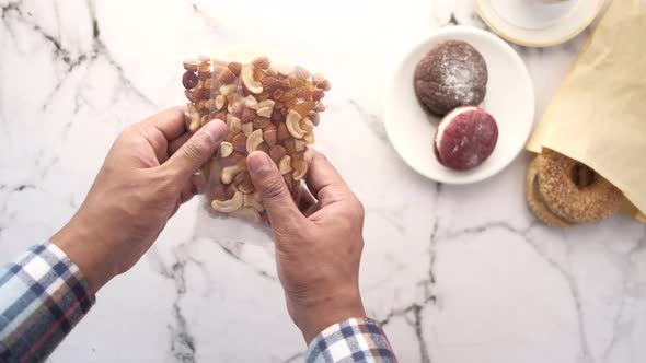 Hand Holding Packer of Mixed Nuts