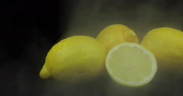 Tropical Fruit Lemon in Cold Ice Clouds of Fog Smoke on Black Background
