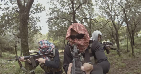 POV footage of armed terrorists patrolling a forest area