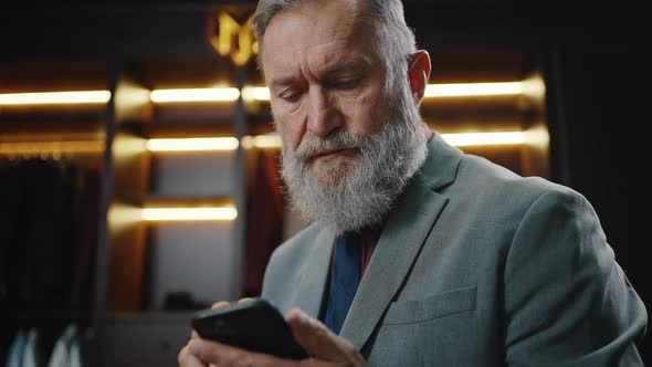 Close Up Portrait of Mature Bearded Businessman Typing on Smartphone Chatting Online with Partners