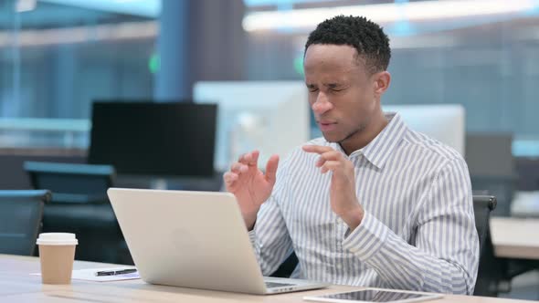 Young African Businessman with Laptop Having Headache