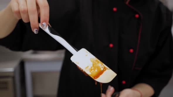 Caramel Drips From the Spoon. The Process of Preparing Caramel in the Kitchen.