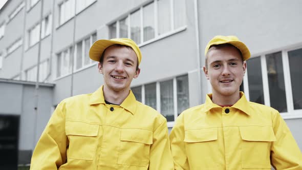 Two Men in Yellow Uniform Smiling Happy