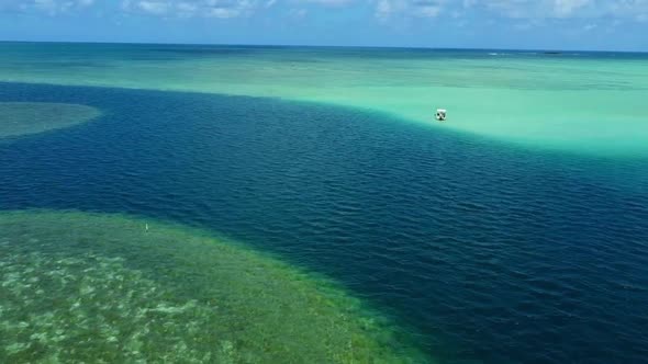 Flying towards edge of Kaneohe Sandbar  over calm turquoise water in Oahu, Hawaii