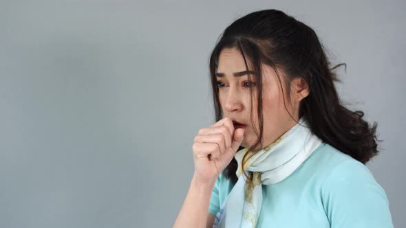 Sick young woman is coughing