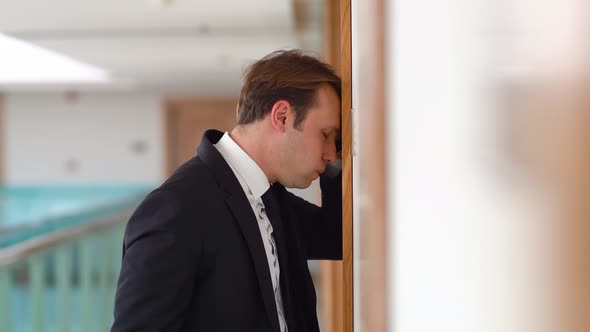 Businessman punching the wall in sadness.