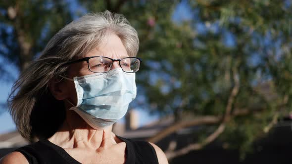 A woman hospital patient wearing a medical mask outdoors to prevent the spread of contagious illness