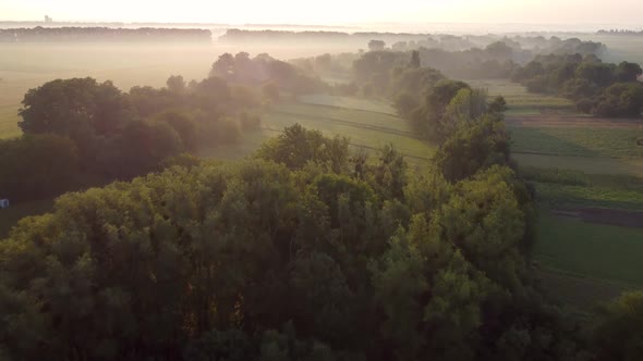 Aerial View Morning Fog at Sunrise Flight Over Trees and Valley in the Countryside