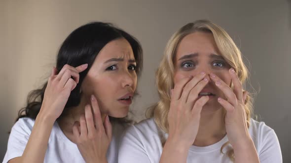 Teen Female Friends Looking in Mirror, Noticing Pimples on Face, Problem Skin