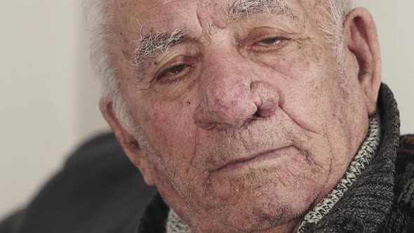 Interrogative, intense and sad look of an elderly man staring at the camera