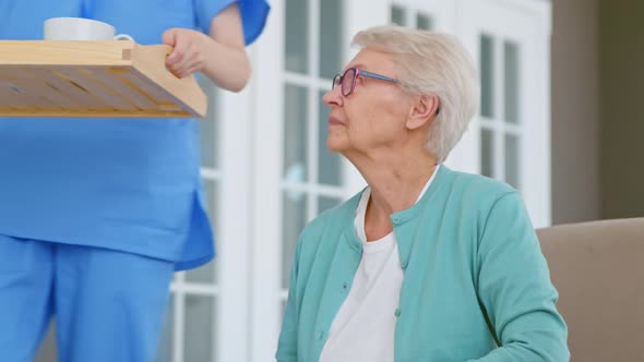 Caretaker carries tray with breakfast and hugs positive single lady