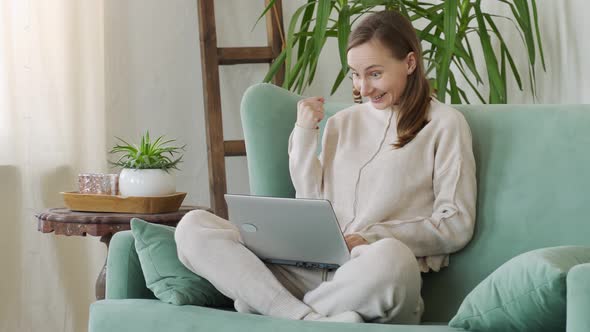 Happy Woman Excited and Glad of Success with Laptop on Chair