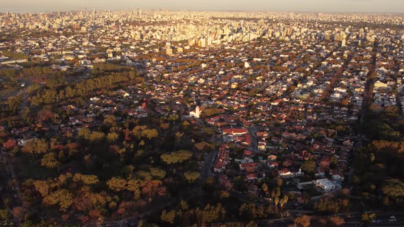 circular drone view of the residential area in the city of Buenos Aires at sunset with the green sub