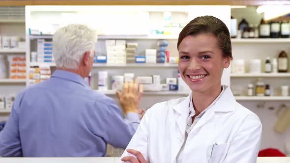 Pharmacist standing with arms crossed in pharmacy