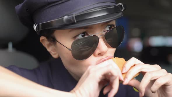 Hungry Asian Patrolwoman Eating Burger Sitting in Police Car, Greasy Food-To-Go