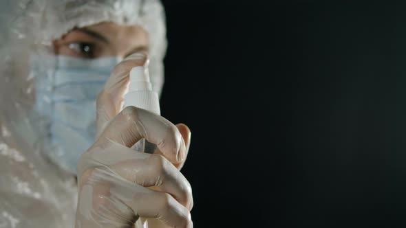 Coronavirus Pandemic. A Doctor in a Medical Mask and Protective Suit Sprays an Antiseptic Spray