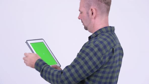 Profile View of Blonde Hipster Man Using Digital Tablet