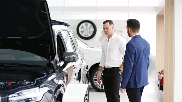 A Male Client Choosing Car at Dealership with the Help of Auto Seller