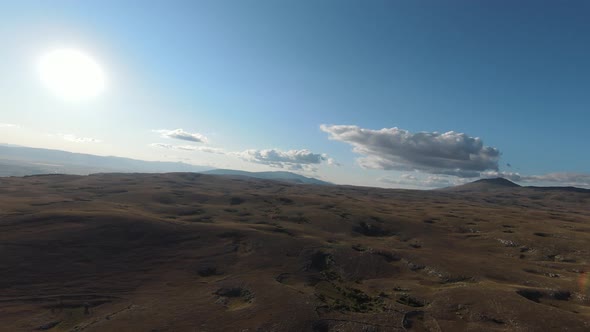 Aerial FPV Drone Shot of a Chasing and Flying Close Around Herd of Wild Horses Running on a Field at